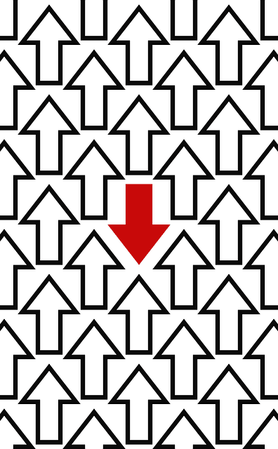 A black and white graphic image of arrows all pointing up, and one red arrow in the middle, pointing down.