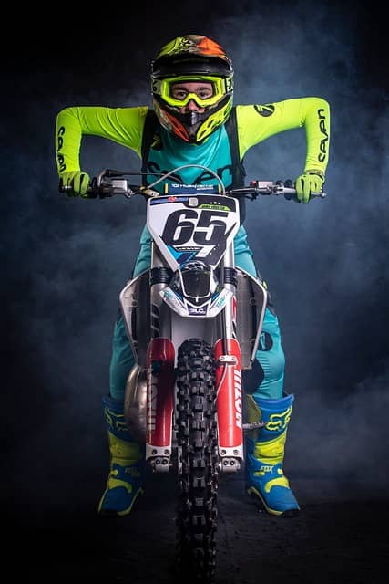 An image of a motorcross rider posed to ride their bike in a race.