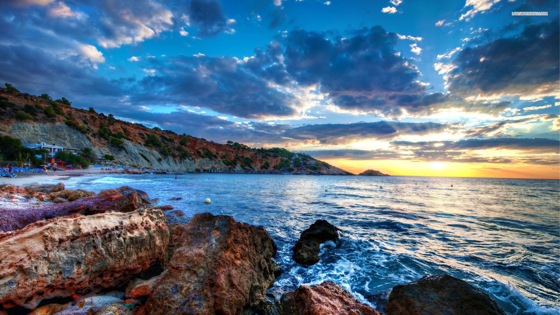 Sunset along the shores of a rocky beach.