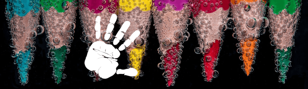 Colored pencils in a row, plunging into water. Bubbles cover the pencils over a black background. A white hand print is placed on the image.