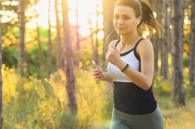 A woman jogs through a nature area